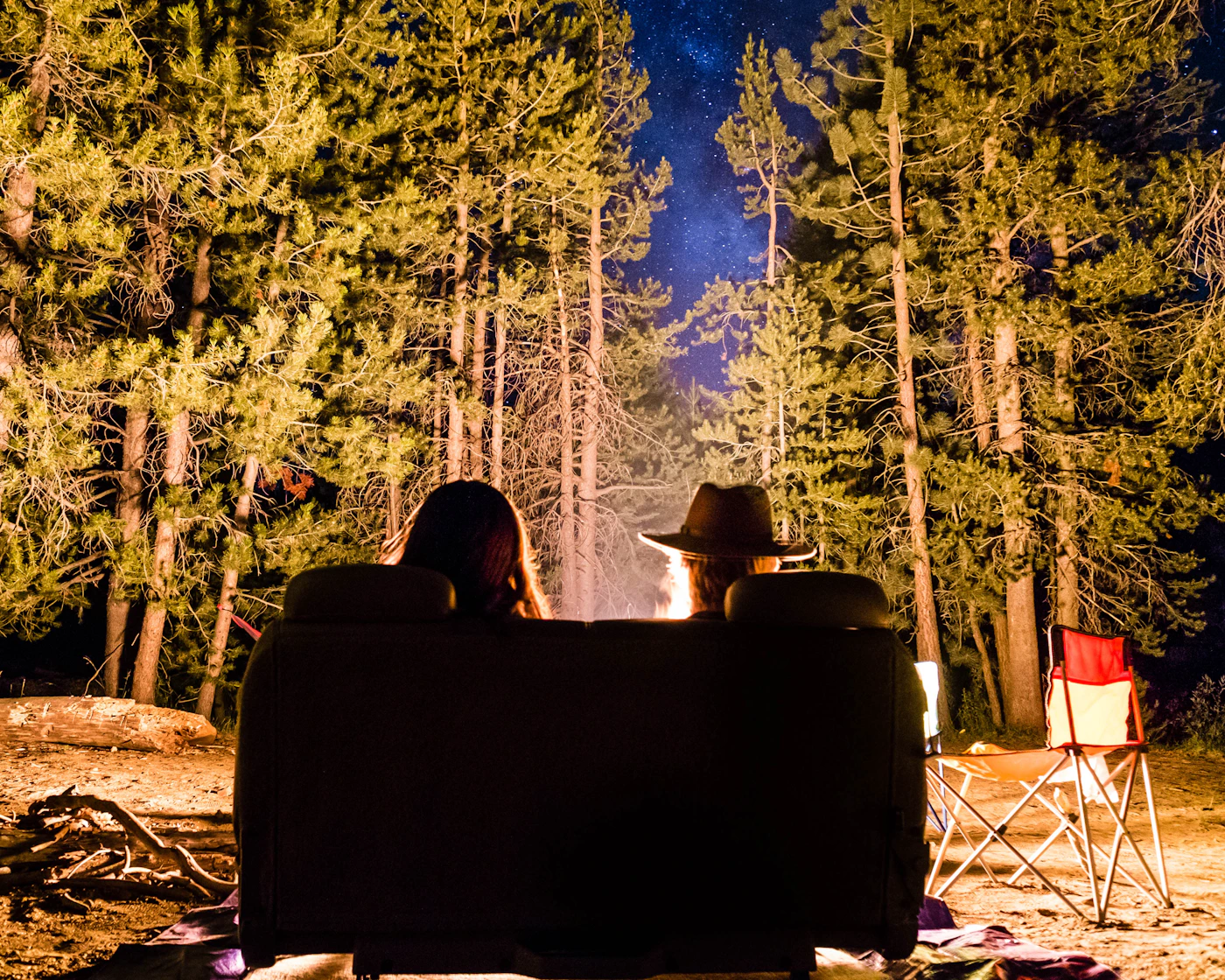 Friends sitting together beside a glowing campfire